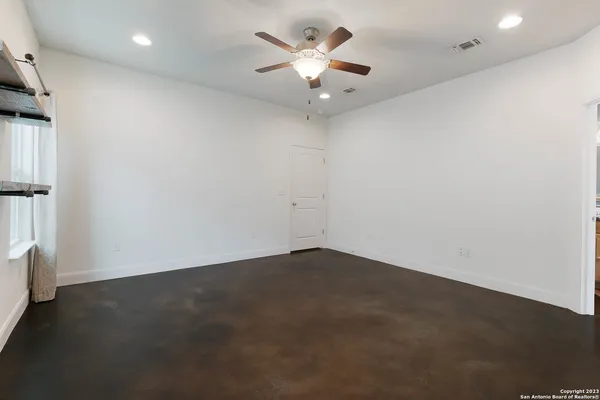 an empty room with a ceiling fan and a window