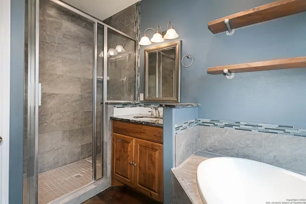 a bathroom with a granite countertop sink mirror and shower