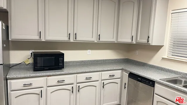 a kitchen with granite countertop white cabinets and a white stove