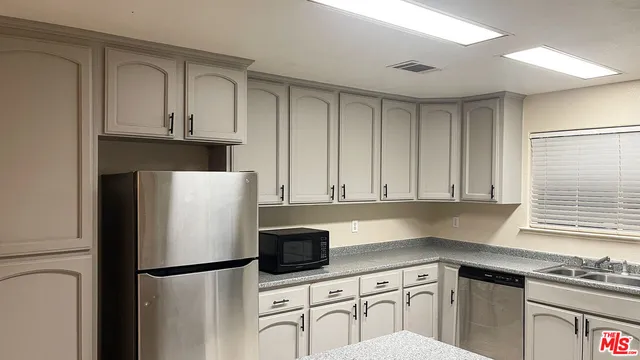 a kitchen with stainless steel appliances a refrigerator sink and cabinets