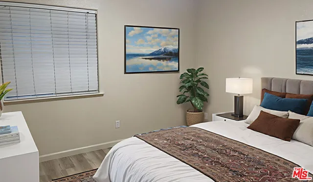 a bedroom with a bed and a painting on the wall