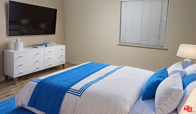 a bedroom with a bed and flat screen tv