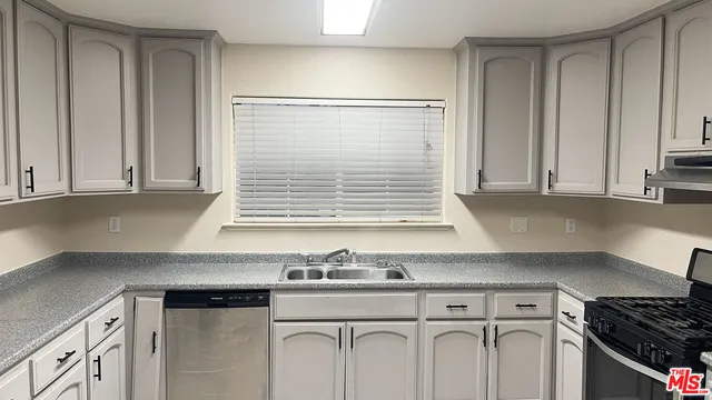 a kitchen with granite countertop a sink and a stove