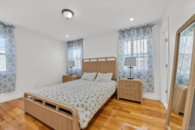 a bedroom with a bed and large windows