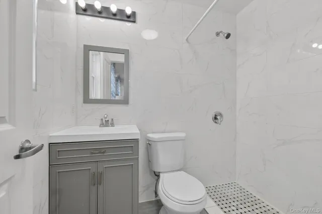 a bathroom with a toilet a sink a vanity and mirror