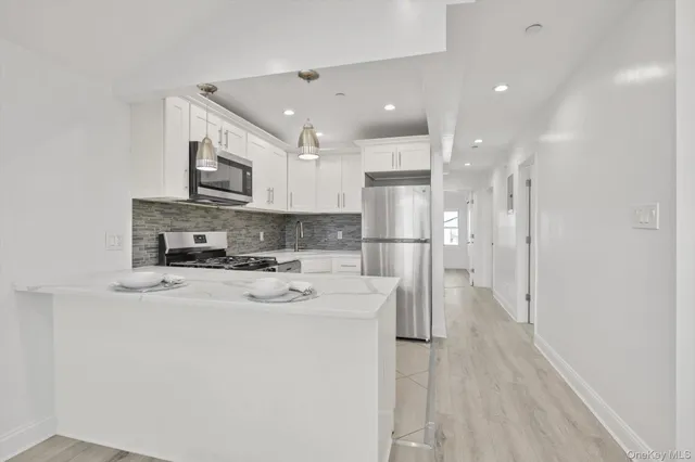 a kitchen with stainless steel appliances a refrigerator sink and microwave