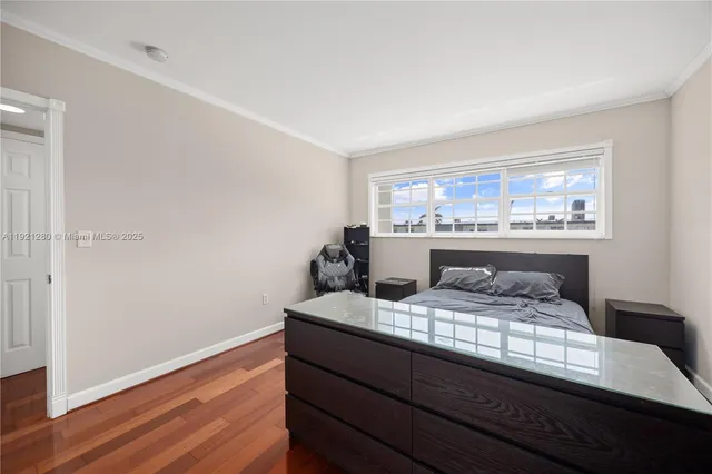 a room with a large bed and wooden floor