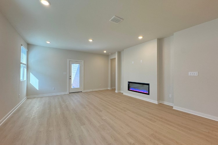 6508 Smarty Jones Lane Buda, TX 78610 - Photo 3 of 9 an empty room with wooden floor closet and windows