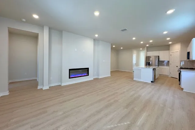 a view of a room with kitchen and hall with wooden floor