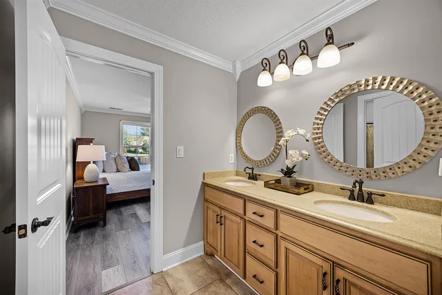 a en suite bathroom with a granite countertop double vanity sink and a mirror