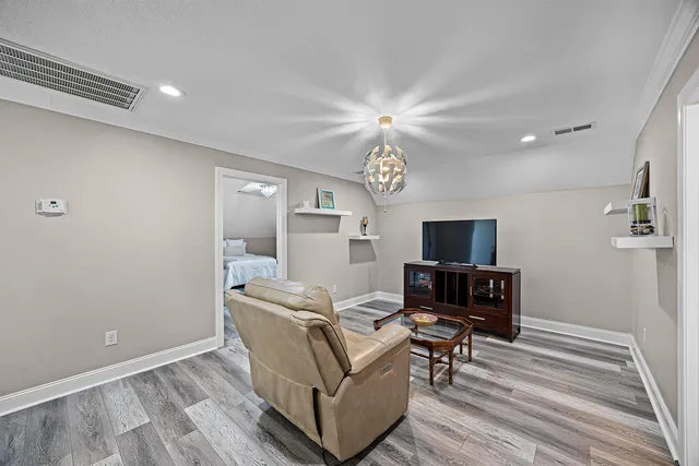 a living room with furniture wooden floor and a flat screen tv