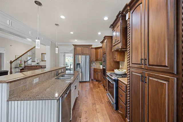a kitchen with stainless steel appliances granite countertop lots of counter top space and wooden floor