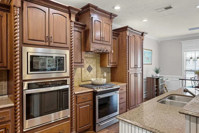 a kitchen with stainless steel appliances granite countertop a stove microwave and refrigerator