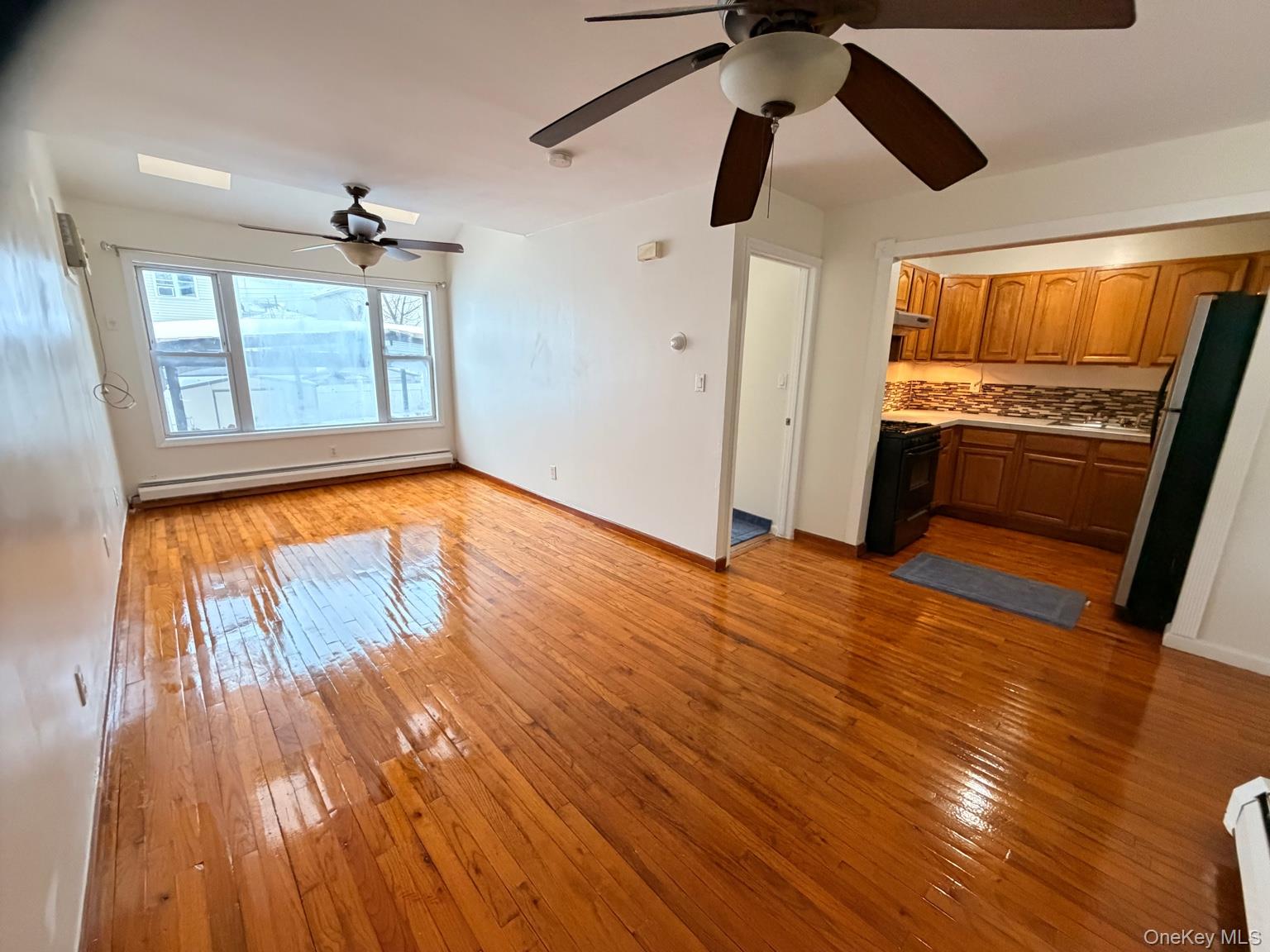 153-17 110th Road, Unit 1R Queens, NY 11433 - Photo 2 of 14 a view of empty room with wooden floor and fan