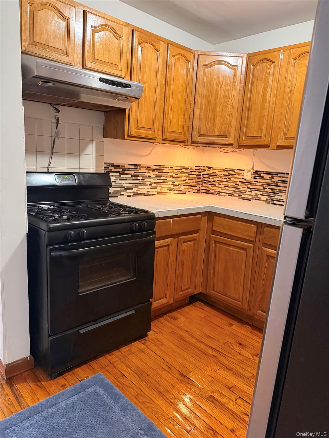 153-17 110th Road, Unit 1R Queens, NY 11433 - Photo 5 of 14 a kitchen with stainless steel appliances granite countertop a stove a sink and a refrigerator