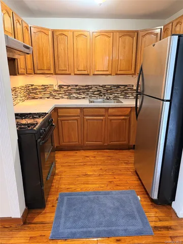 a view of a kitchen with wooden floor and a sink