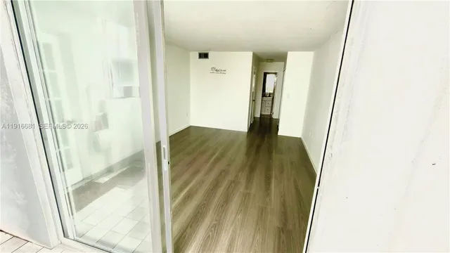 a view of a room with wooden floor and large window