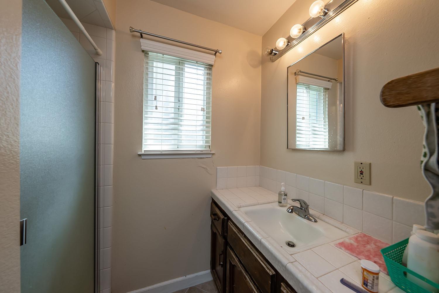 653 Meadow Lane Lemoore, CA 93245 - Photo 16 of 43 a bathroom with a sink vanity tub and a toilet