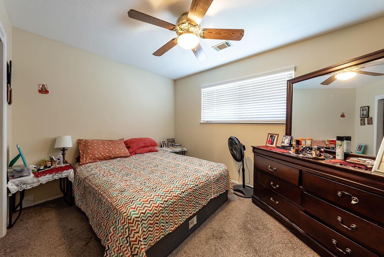 653 Meadow Lane Lemoore, CA 93245 - Photo 19 of 43 a bedroom with a bed and a dresser in it