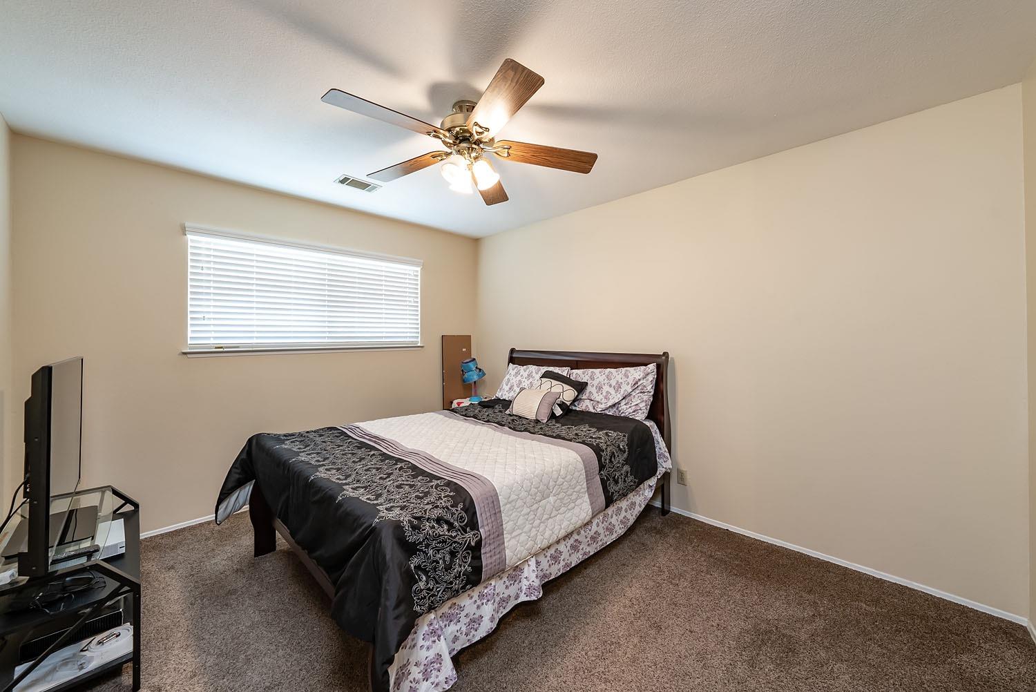653 Meadow Lane Lemoore, CA 93245 - Photo 23 of 43 a bedroom with a bed and a chandelier