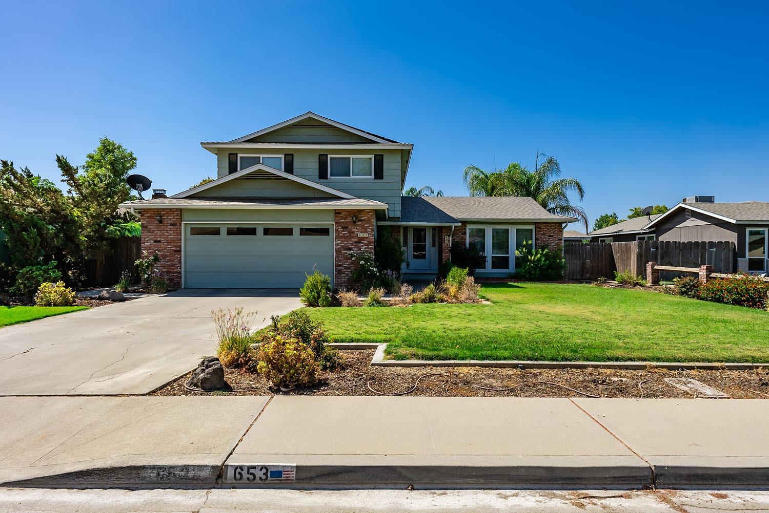 653 Meadow Lane Lemoore, CA 93245 - Photo 3 of 43 a front view of a house with a yard