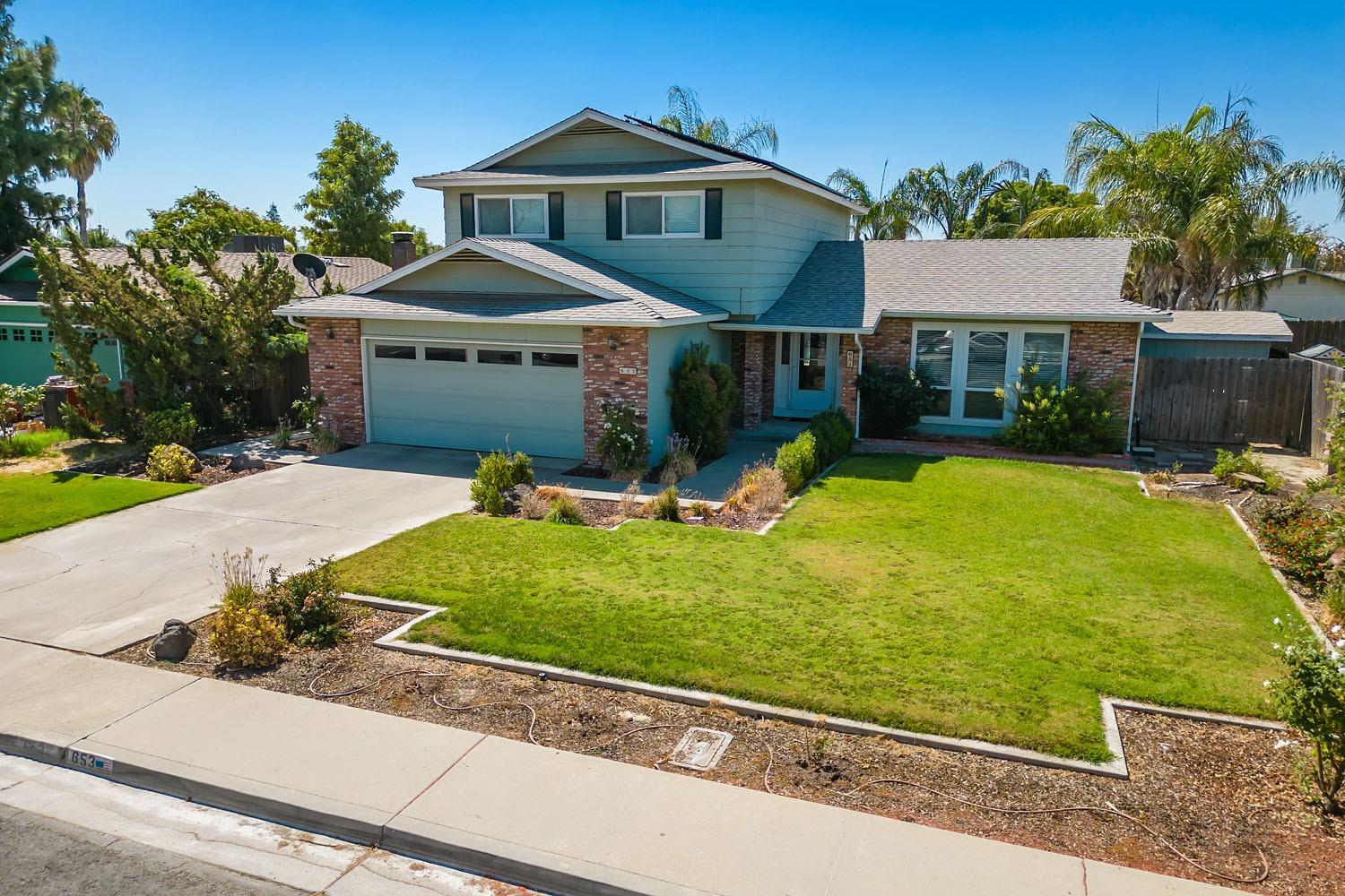 653 Meadow Lane Lemoore, CA 93245 - Photo 33 of 43 a front view of a house with garden