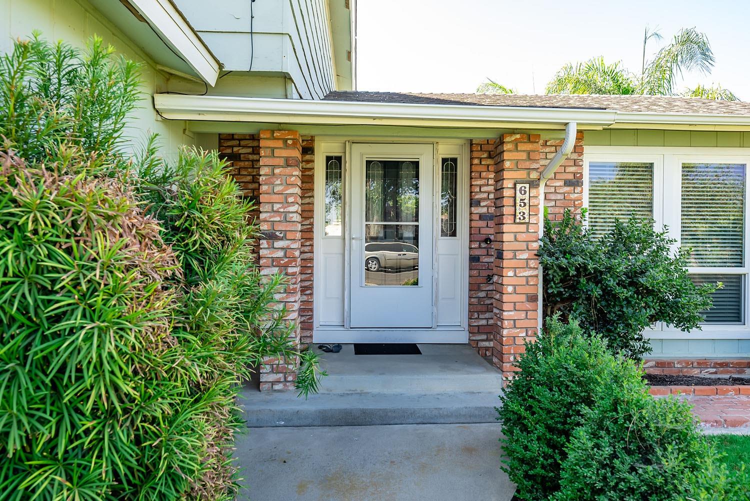 653 Meadow Lane Lemoore, CA 93245 - Photo 4 of 43 a front view of a house with a yard