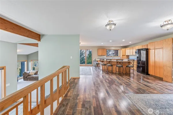 a view of a living room and kitchen with furniture wooden floor and windows