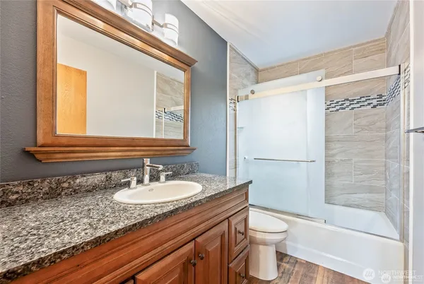 a bathroom with a granite countertop sink toilet and shower