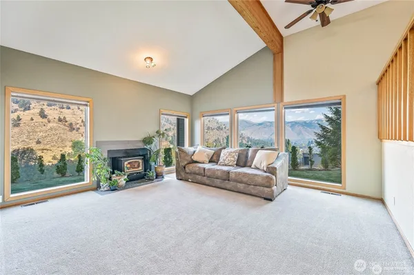 a living room with furniture a fireplace and a floor to ceiling window