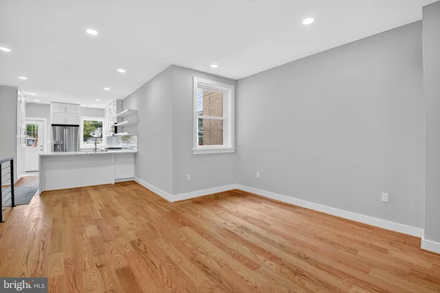 a view of a kitchen with wooden floor and a window
