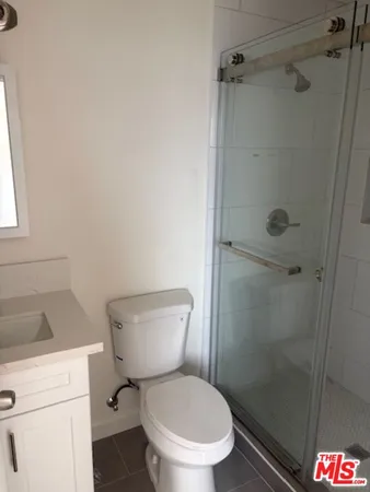 a white toilet sitting next to a shower