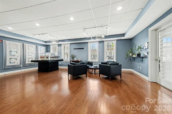a living room with furniture a flat screen tv and kitchen view