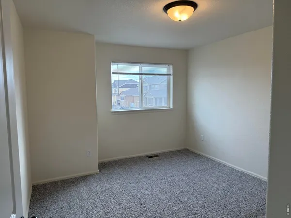 an empty room with window and closet