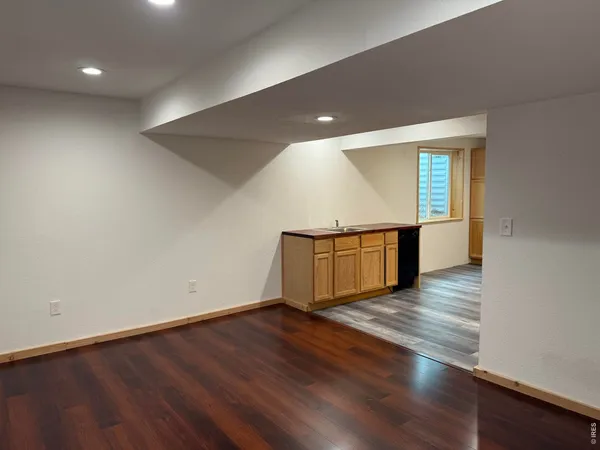 an empty room with wooden floor and entrance