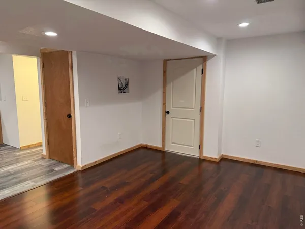 an empty room with wooden floor and closet area