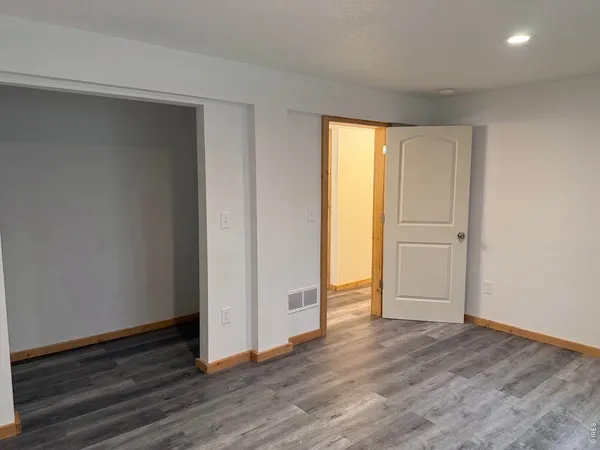 an empty room with wooden floor and closet