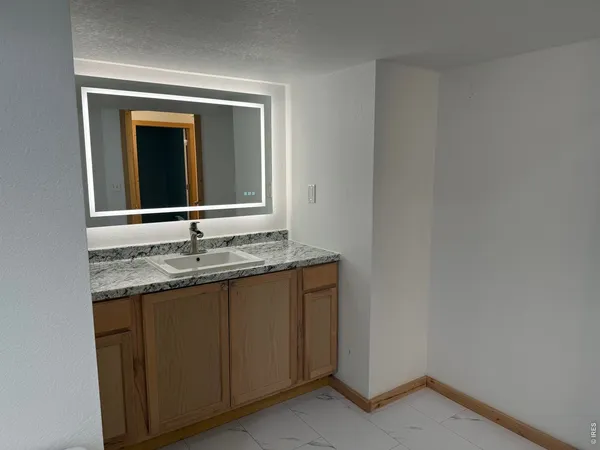 a bathroom with a granite countertop sink and a mirror