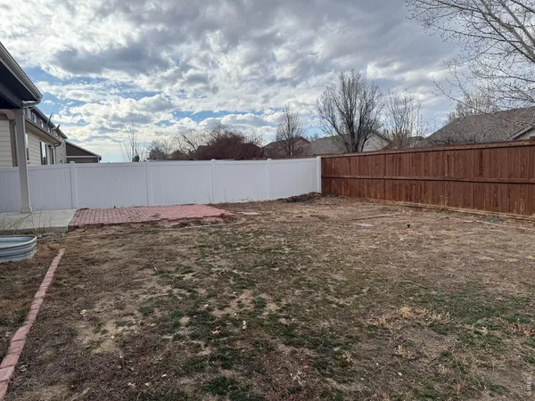 a view of backyard with wooden fence
