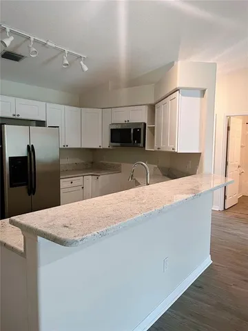 a view of a room with wooden floor and chandelier