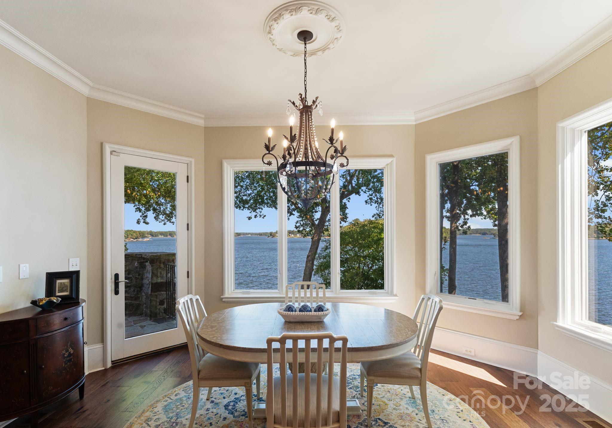 115 Emerald Point Lane Mooresville, NC 28117 - Photo 11 of 38 a dining room with furniture a chandelier and wooden floor
