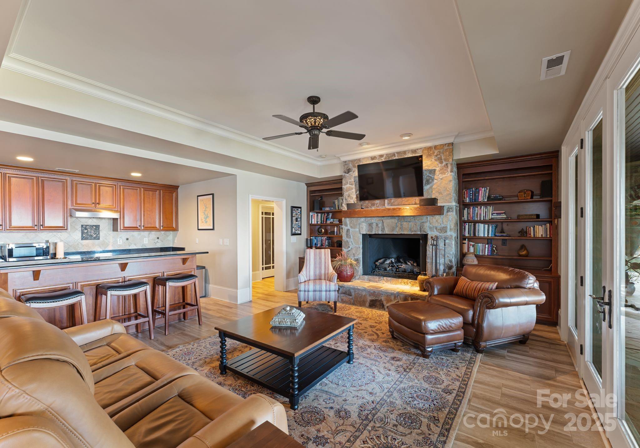 115 Emerald Point Lane Mooresville, NC 28117 - Photo 23 of 38 a living room with furniture a fireplace and a flat screen tv