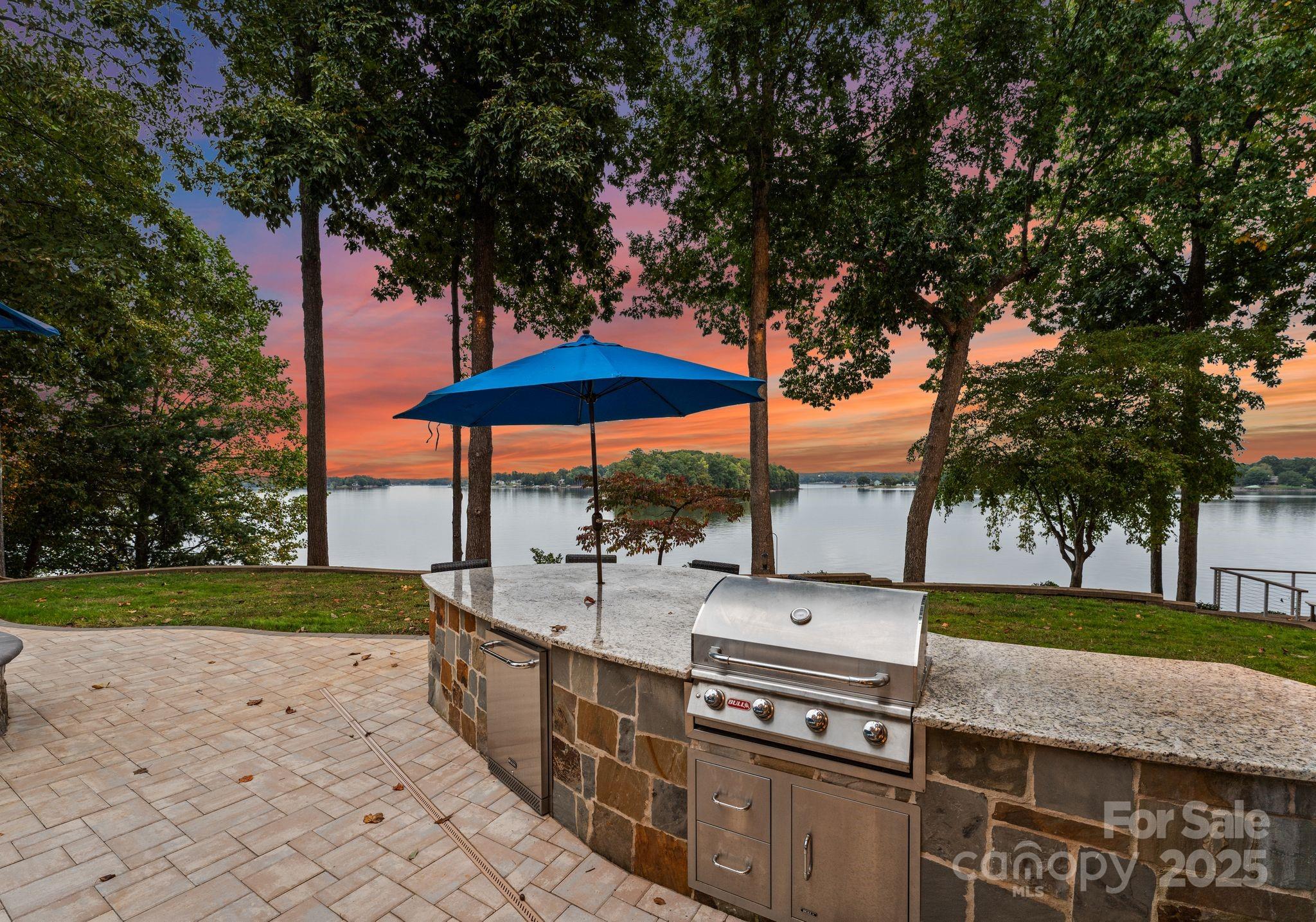 115 Emerald Point Lane Mooresville, NC 28117 - Photo 33 of 38 a view of a backyard with a sink and table under an umbrella