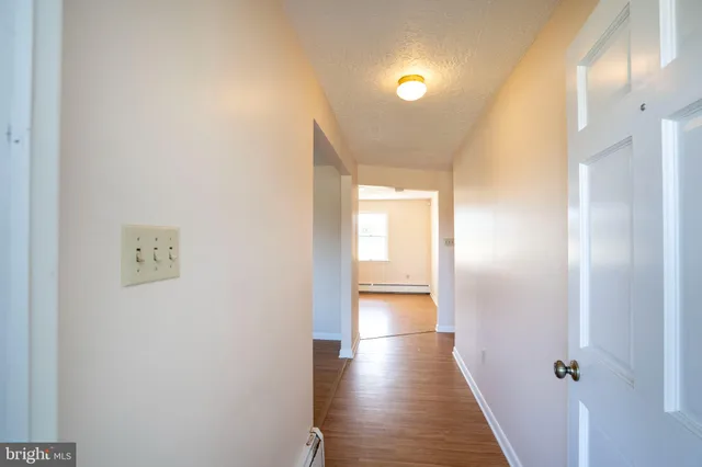 a view of a hallway with wooden floor