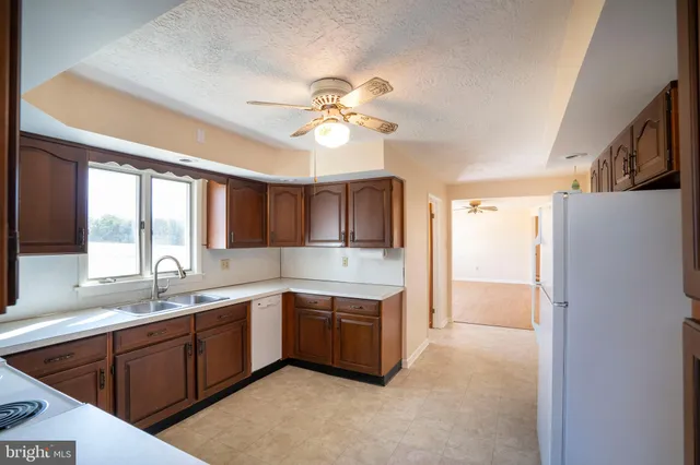 a kitchen with a sink a refrigerator and cabinets