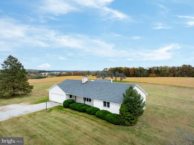 a aerial view of a house with big yard and a large tree