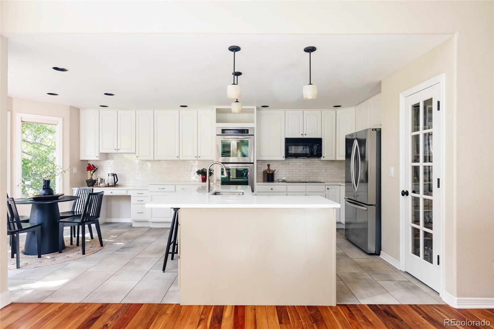 1347 Pine View Road Golden, CO 80403 - Photo 12 of 50 a living room with stainless steel appliances granite countertop furniture a kitchen island a stove a refrigerator a dining table and chairs with wooden floor