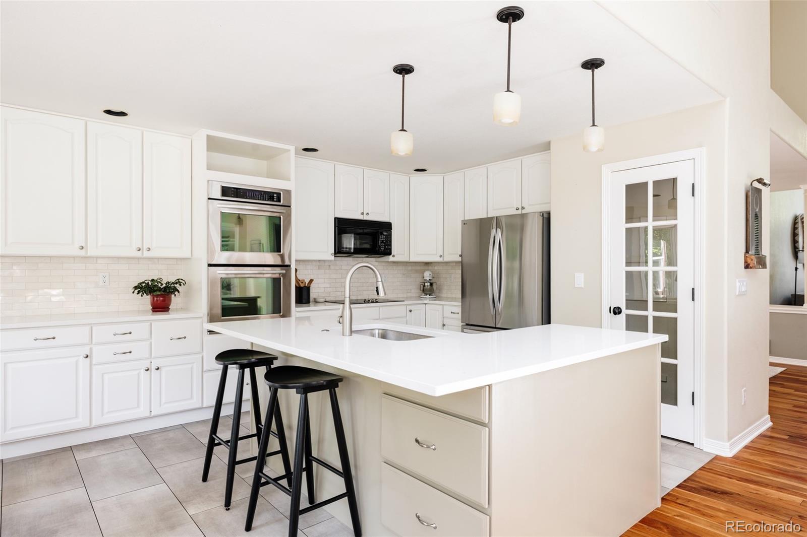 1347 Pine View Road Golden, CO 80403 - Photo 13 of 50 a kitchen that has a lot of white cabinets and stainless steel appliances