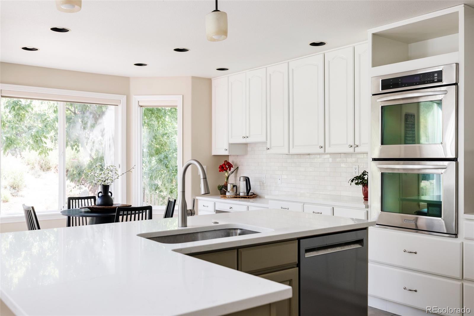 1347 Pine View Road Golden, CO 80403 - Photo 14 of 50 a kitchen with kitchen island a sink appliances cabinets and a large window