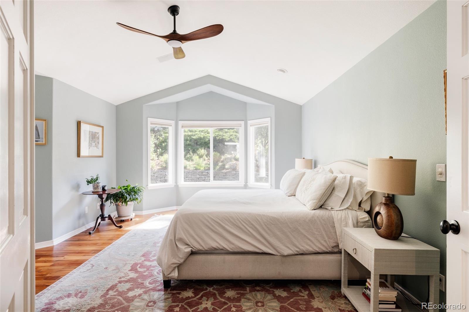 1347 Pine View Road Golden, CO 80403 - Photo 18 of 50 a bedroom with a bed and wooden floor
